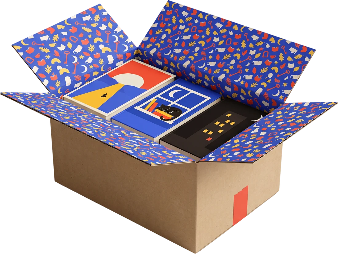 An open kraft cardboard box lined with the Endpaper pattern and packed with three hardcover books