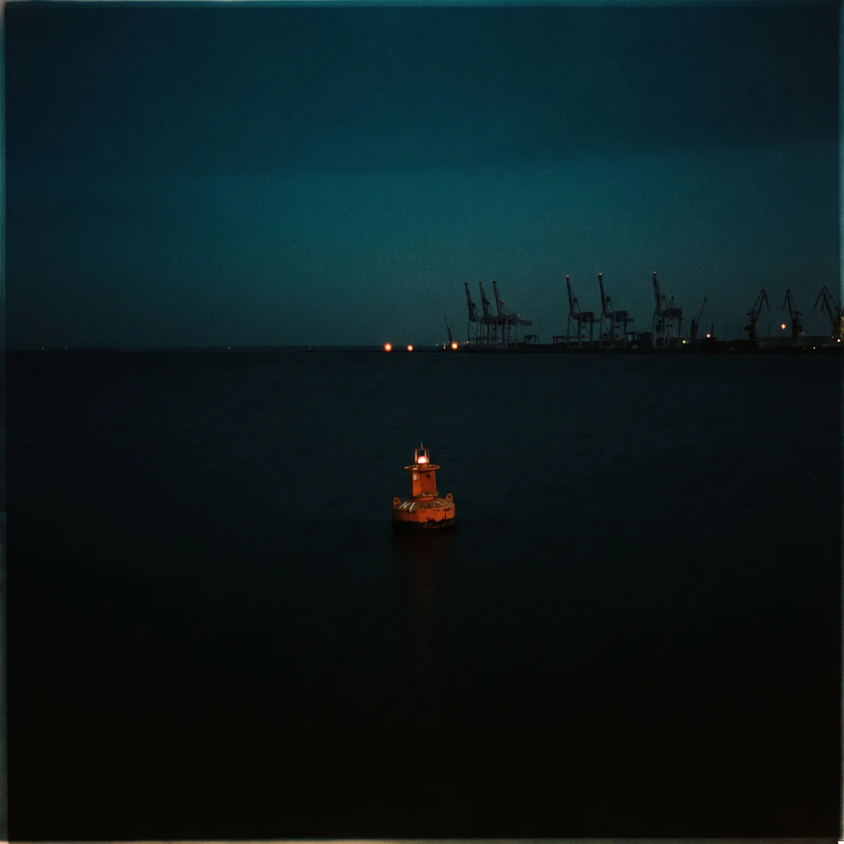 Cover art: one orange buoy floating alone on black water at night