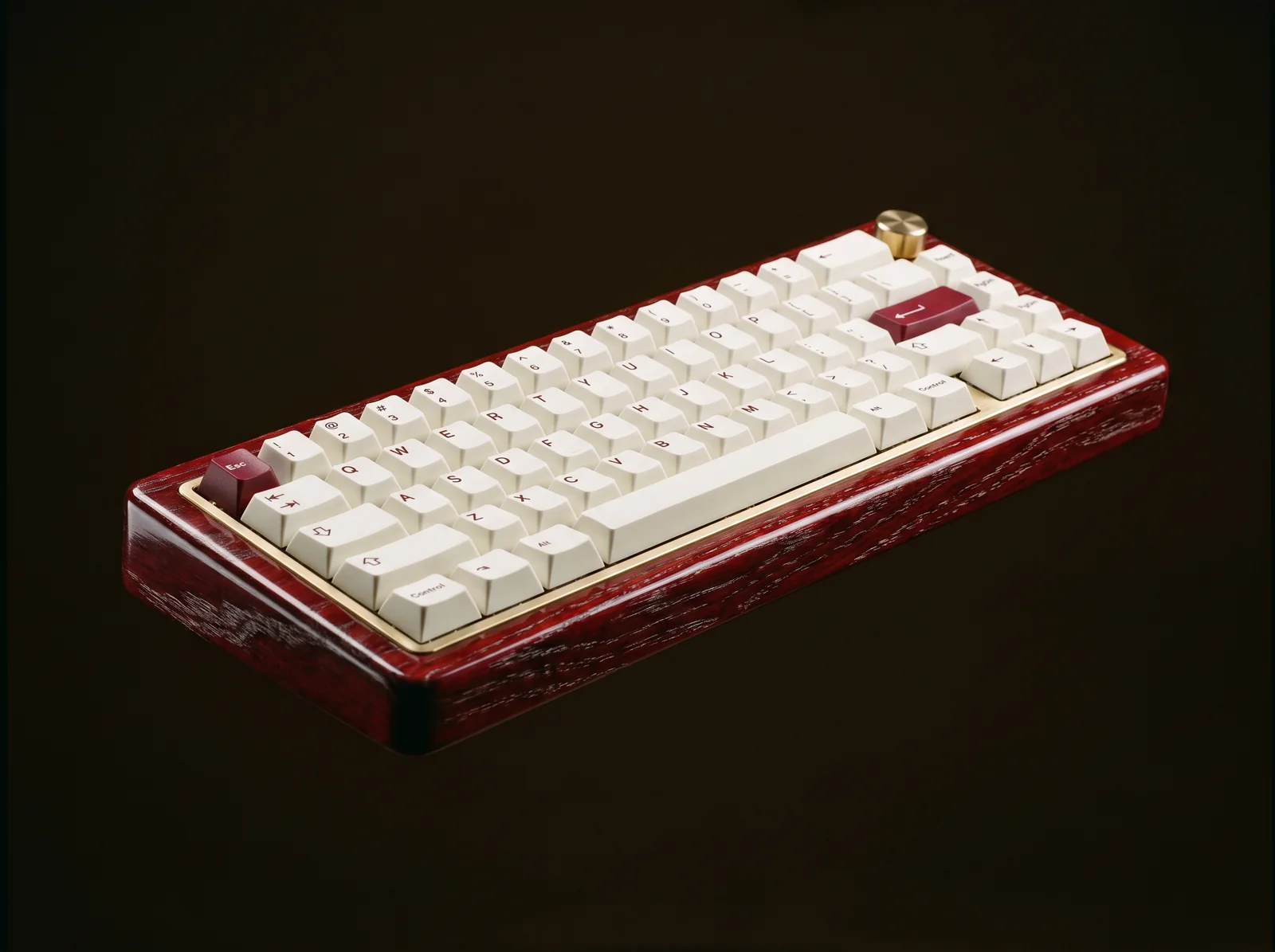 The Lacewood keyboard in three quarter view, red lacquered case, brass plate and ivory keycaps