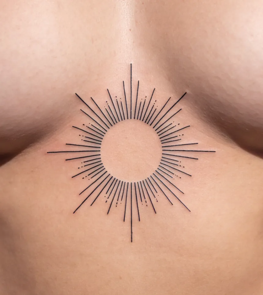 A geometric sunburst tattooed on a sternum