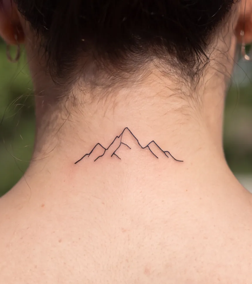 A minimal mountain line tattooed on the back of a neck
