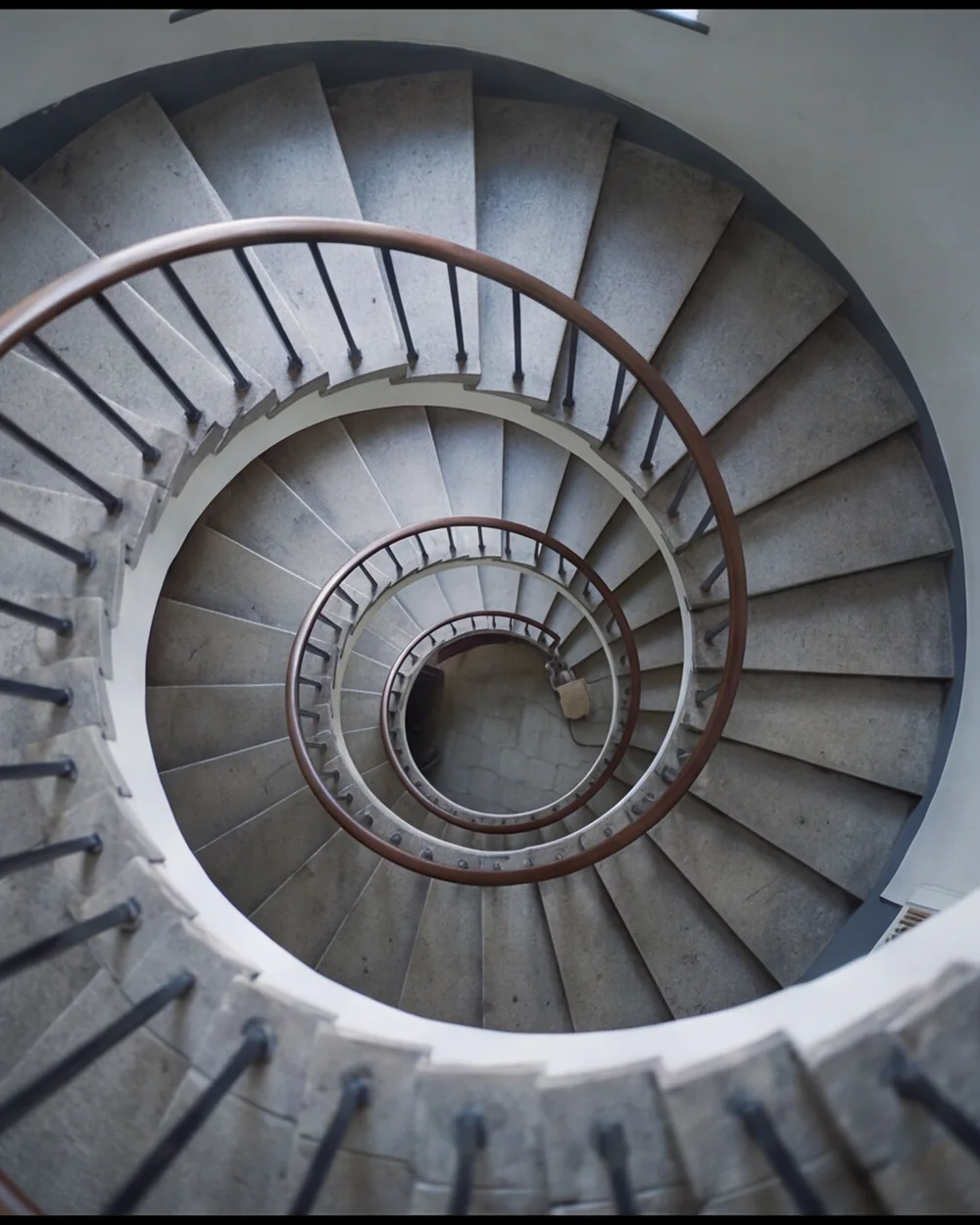 A spiral stone stairwell photographed from directly above