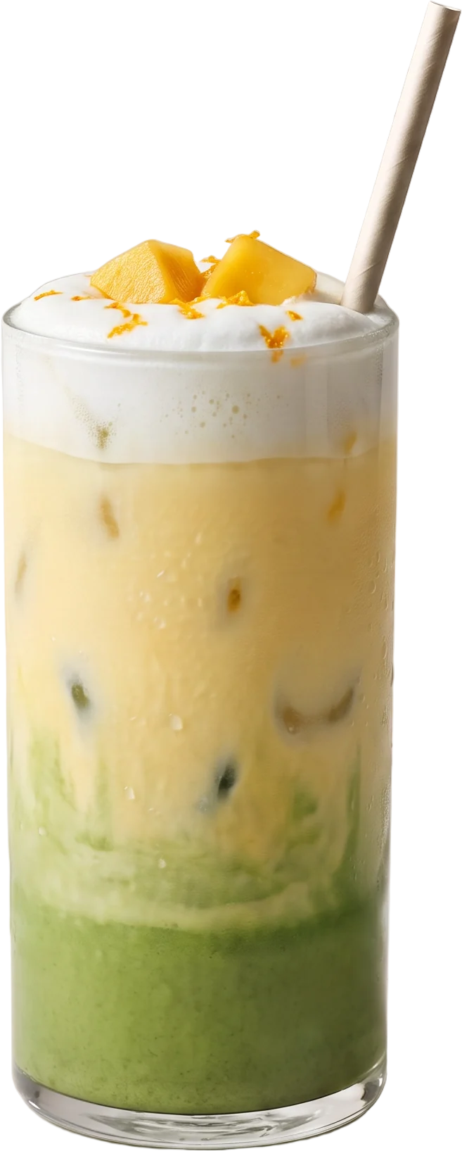 The same glass with soft mango-yellow milk over the green layer and two fresh mango cubes on the foam